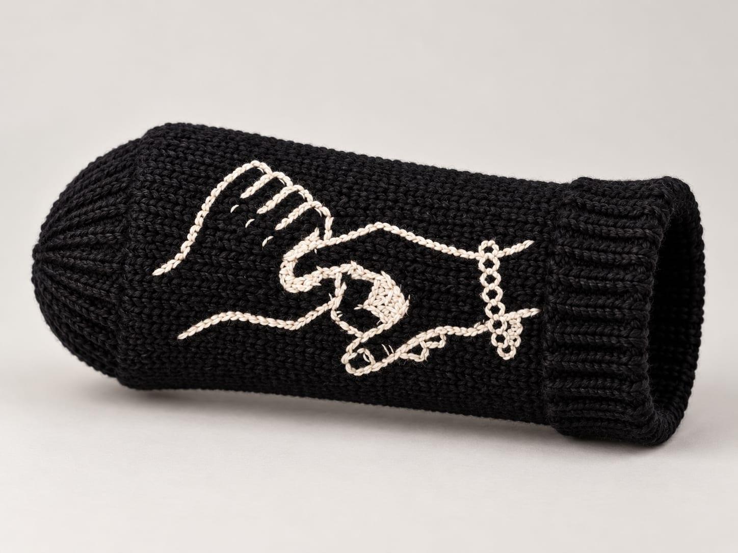 Black knit warmer with a closed end and the hands mark stitched in cream